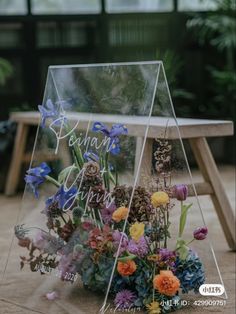 a clear acrylic sign with flowers in it