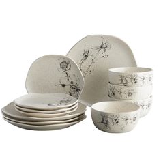 a white and black dinner set with flowers on the front, four plates and one bowl