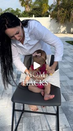 a woman holding a baby sitting on top of a chair with the capt mom hacks