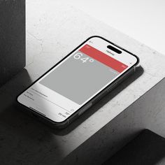 a cell phone sitting on top of a cement wall next to a concrete block with a red and white number forty