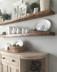 two wooden shelves above a table with plates and bowls on it, one shelf holding dishes