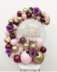 a birthday cake with balloons and flowers around it