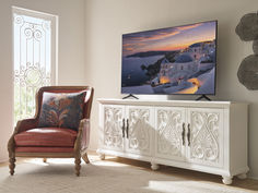 a large flat screen tv sitting on top of a white cabinet in a living room