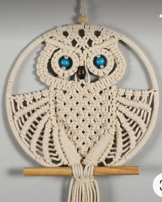 an owl is hanging on the wall with blue eyes