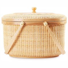 a wicker basket with two wooden handles and straps on the handle, sitting against a white background