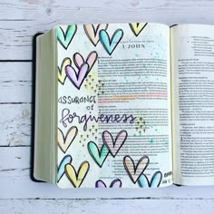 an open bible with hearts drawn on it