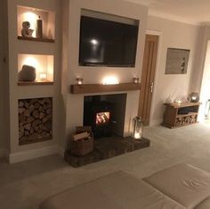 a living room filled with furniture and a flat screen tv mounted on the wall above a fire place