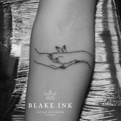 a black and white photo of two hands holding each other with the word,'blake ink tattoo & piercing