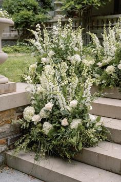 white flowers and greenery are growing on the steps