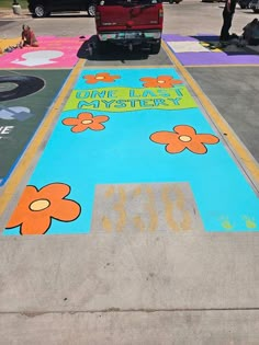 the sidewalk has been painted with flowers and words