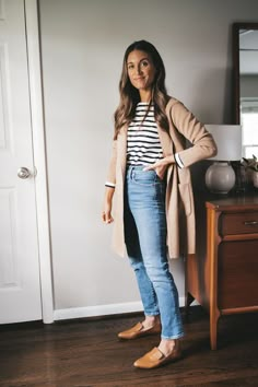 ashley wearing a black and white striped breton top, tan long line sweater blazer, medium wash denim, and cognac loafers standing next to a vintage wood dresser with a white table lamp Style Parisienne, Looks Jeans, Autumn Looks, Fall Capsule Wardrobe, Teacher Outfits, Business Casual Outfits, Mode Inspiration