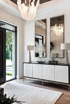 a living room with a large white rug and chandelier