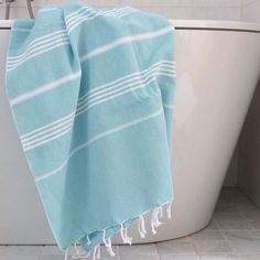 a blue and white towel sitting on top of a bath tub