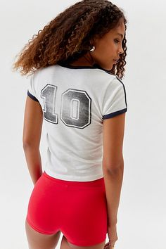 iets frans... soccer ringer baby tee. Shrunken fit baby tee from iets frans... with vintage vibe sport graphics. Ringer style tee with a fitted silhouette that's cropped above the waist in a soft and stretchy knit. Find this iets frans... tee only at Urban Outfitters. Features iets frans... soccer ringer baby tee Vintage style sporty graphic tee Shrunken tee with a cropped fit UO exclusive Content + Care 100% Cotton Machine wash Imported Size + Fit Model is 5’11" and wearing size Medium Measurements taken from size Medium Chest: 14" Length: 22" | iets frans... Soccer Ringer Baby Tee in White at Urban Outfitters Collegiate White Top With Number Print, Collegiate White Tops With Number Print, Retro Tops For Football Season Streetwear, Retro Tops For Streetwear During Football Season, Sporty White T-shirt With Number Print, Retro Tops For College Football Season, Retro Sports Tops, Varsity Fitted Top For Game Day, Sporty Fitted T-shirt For Game Day