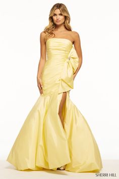 a woman in a yellow dress posing for the camera