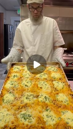 a man in a chef's outfit is holding a pan with food on it