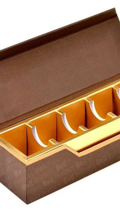 an open box with four compartments and gold trim