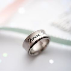 Celebrate the unbreakable bond of friendship with this beautifully crafted "Forever Friends" Spinner Ring. Engraved with a heartfelt message against a sophisticated brushed stainless steel band, this ring is a constant reminder of the cherished relationship you share with your best friend. The smooth spinning feature adds a fun, fidget-friendly element, providing a soothing and engaging sensory experience. Wear this stylish and meaningful ring every day to keep your friend close, even when you'r Stainless Steel Promise Rings For Valentine's Day, Adjustable Engraved Stainless Steel Rings, Adjustable Stainless Steel Engraved Ring, Minimalist Engraved Stainless Steel Promise Ring, Valentine's Day Promise Ring In Stainless Steel, Minimalist Stainless Steel Engraved Promise Ring, Stainless Steel Ring With Brushed Finish As Gift, Stainless Steel Ring With Brushed Finish For Gift, Brushed Finish Stainless Steel Rings For Gift