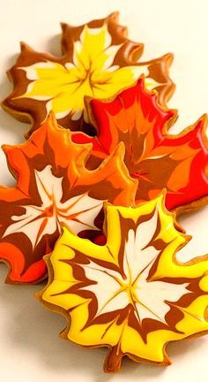 three leaf shaped cookies sitting next to each other on top of a white countertop