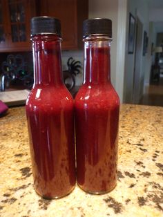 two red bottles sitting on top of a counter