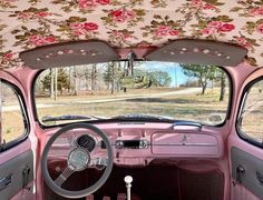 the interior of an old pink car with floral fabric on it's dash board