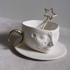 a white cup with a gold ring on it and a small star in the middle