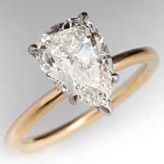 an oval cut diamond sits on top of a yellow gold band