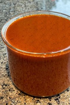 a glass container filled with sauce sitting on top of a counter