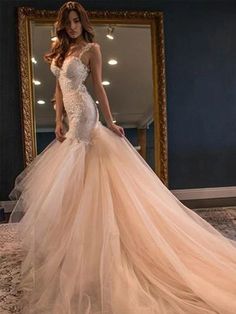 a woman standing in front of a mirror wearing a wedding dress