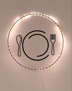 a plate with a knife, fork and spoon on it is lit up in the shape of a circle