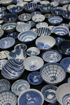 many blue and white bowls are stacked on top of each other in the shape of circles