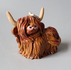 a ceramic sculpture of a yak with horns on it's head and long hair