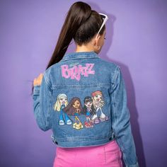 Bratz Denim Jacket. Featuring A Nostalgic, Y2k Cropped Vibe, This Jacket Is Adorned With Scorchin’ Bratz Graphics, Making It A Must-Have For Any Fashion-Forward Individual. The Bratz Denim Jacket Features Embroidered Lips On The Collar, Gold Button Detail And The Ultimate Printed Design On The Back Of The Core Four Bratz Girls, Cloe, Sasha, Jade And Yasmin Along With The Bratz Logo. Crafted From High-Quality Denim, This Jacket Is Durable, Super Comfortable And Perfect For All Seasons. Embroidere Fitted Blue Denim Jacket With Graphic Print, Fitted Denim Jacket With Graphic Print In Medium Wash, Fitted Graphic Print Outerwear, Embroidered Lips, Bratz Logo, Core Four, The Bratz, Bratz Girls, Burning Man Fashion