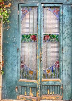 an old door with stained glass and flowers on it