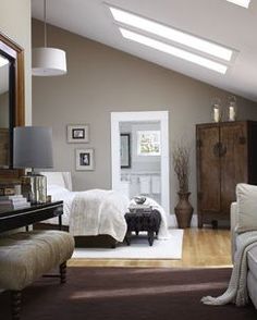 a bedroom with white walls and wooden floors