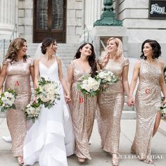 a group of women standing next to each other in front of a building with flowers