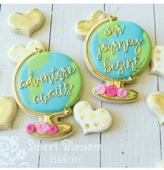 two decorated cookies with the words adventure await on them next to hearts and cookie cutters