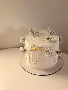 a white cake with flowers and the word love on it