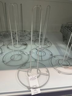 a display case filled with lots of metal wire and plastic tubes on top of a white counter