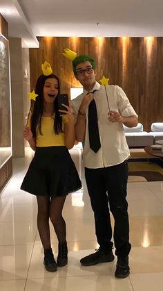 a man and woman dressed up as pikachu and the girl is holding a cell phone