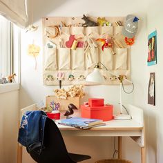 a desk with a chair, lamp and pictures on the wall in front of it