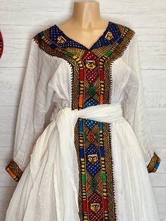 Beautiful Ethiopian and Eritrean Habeshan Dress. Stylish Menen, 100% Cotton We recommend hand washing and air drying to make it last longer. A low heating iron will also keep design and look. Cotton, it doesn't have a pocket. Traditional White Fitted Habesha Kemis, Traditional Fitted White Habesha Kemis, Festive White Tunic Dress, White Folk Dress For Eid, Fitted White Habesha Kemis For Traditional Ceremonies, White Fitted Habesha Kemis For Traditional Ceremonies, Traditional White Long Sleeve Habesha Kemis, White Folk Style Habesha Kemis, Ceremonial Long Sleeve Habesha Kemis With Traditional Patterns