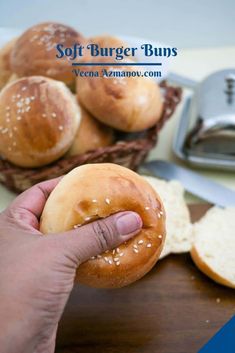 a person holding a bagel in front of some bread