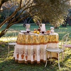 the table is set with tea and fruit for two people to enjoy in the garden