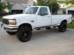 a white pick up truck parked in front of a house