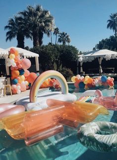 an inflatable pool with balloons floating on it's sides and other decorations