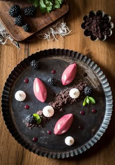 a chocolate dessert with raspberries and blackberries on top sits in a pie pan