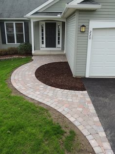 a house with a driveway in front of it and grass on the ground next to it