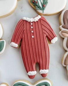 decorated cookies with frosting and icing are arranged in the shape of santa's pajamas