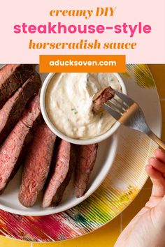 a plate with steaks and cream sauce on it, next to a hand holding a fork